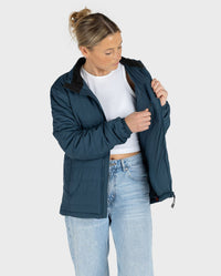 Woman wearing dryrobe Mid-layer Jacket in Deep Sea Blue, opening inner pocket