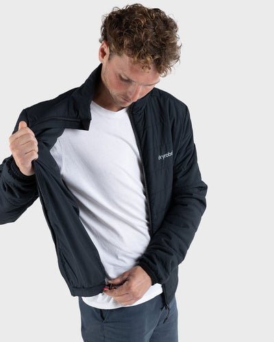 Man wearing dryrobe Mid-Layer Jacket in Black, pulling the adjustable waistband toggle 