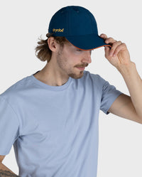 *MALE* Man wearing Deep Sea Blue dryrobe Quick Dry Cap, holding onto the peak of the cap