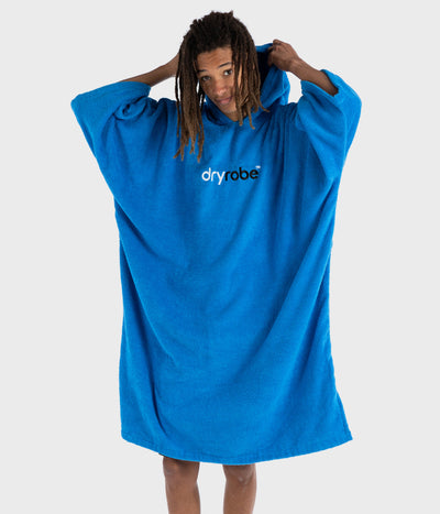 Man putting hood up on Cobalt Blue Organic Towel dryrobe® poncho