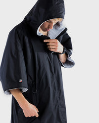 1|Man wearing Black Grey dryrobe® Advance Short Sleeve with hood up 
