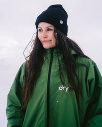 Woman wearing Forest Green dryrobe® Advance Long Sleeve and Black dryrobe® Eco beanie 