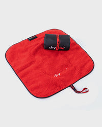 Rolled up Black Red dryrobe® Change Mat, placed on top of one laid out flat
