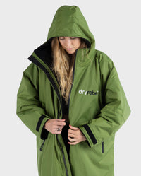 Woman wearing Forest Green dryrobe® Advance Long Sleeve with hood up