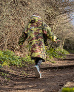 Girl walking up a path wearing Camo Grey Kids dryrobe® Advance Long Sleeve changing poncho 