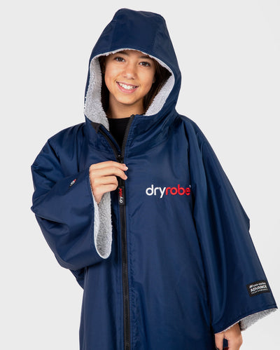 Girl smiling wearing Kids dryrobe Advance Short Sleeve change poncho in Navy Grey with hood up