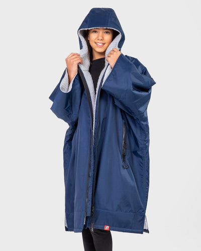 Girl wearing Kids dryrobe Advance Short Sleeve change poncho in Navy Grey unzipped with hood up