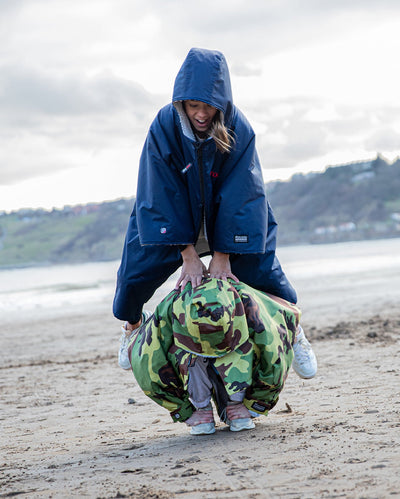 Children playing a jumping game wearing dryrobe® Advance change ponchos