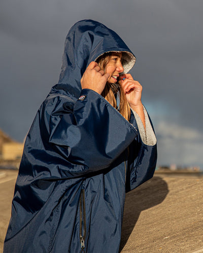 Girl smiling in the sun wearing Navy Grey dryrobe® Advance Kids Short Sleeve change poncho