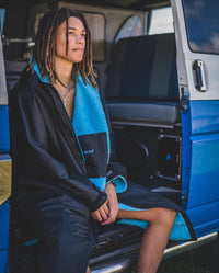 1|*MALE* sitting in a van, wearing Black Blue dryrobe® Advance Long Sleeve