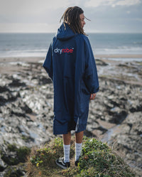 1|*MALE* wearing Navy Grey dryrobe® Advance Long Sleeve, while standing on a cliff facing the sea