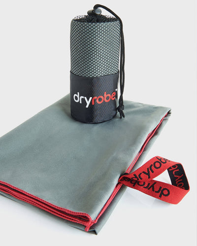 Two dryrobe Microfibre towels, one shown folded up, with another on top inside mesh bag