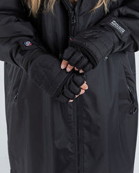 1|Woman wearing dryrobe® Eco Thermal Gloves, with both mitten flaps folded back